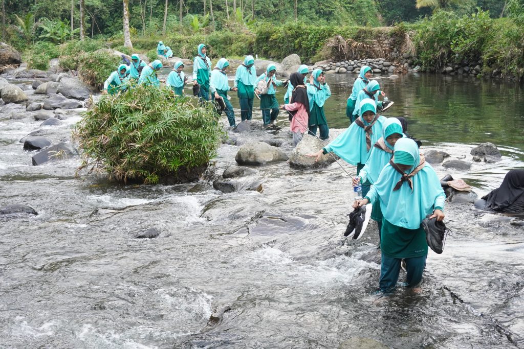 Peserta pramuka penggalang menyusuri kali Banjaran 