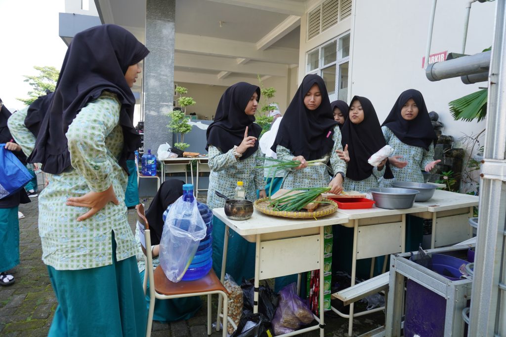 Siswi SMP AABS sedang meracik bahan dagangan untuk dimasak bersama