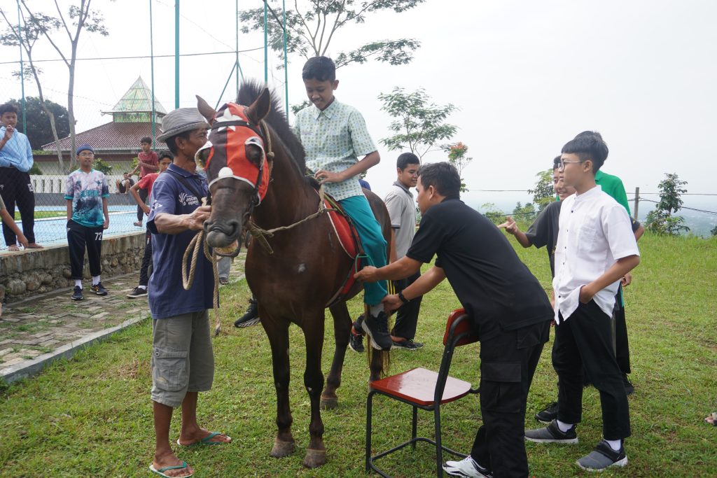 Seorang siswa sedang menunggang kuda