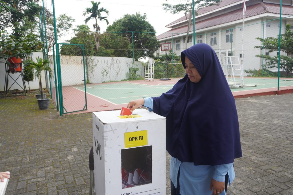 Ustazah Nur sedang memasukkan surat suara